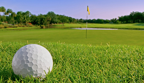 close up of golf ball looking to the green in the background